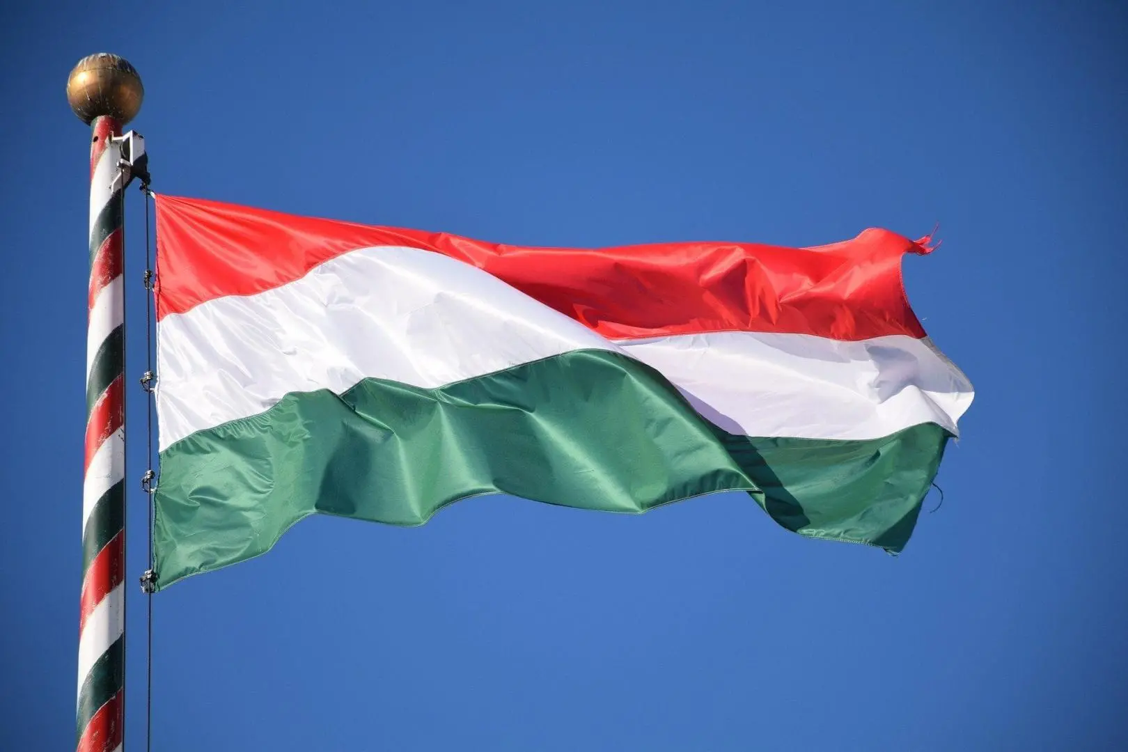 Ezen a képen a Magyar zászló látható, ahogy lobog a szélben, nemzeti színű zászlórúdon
